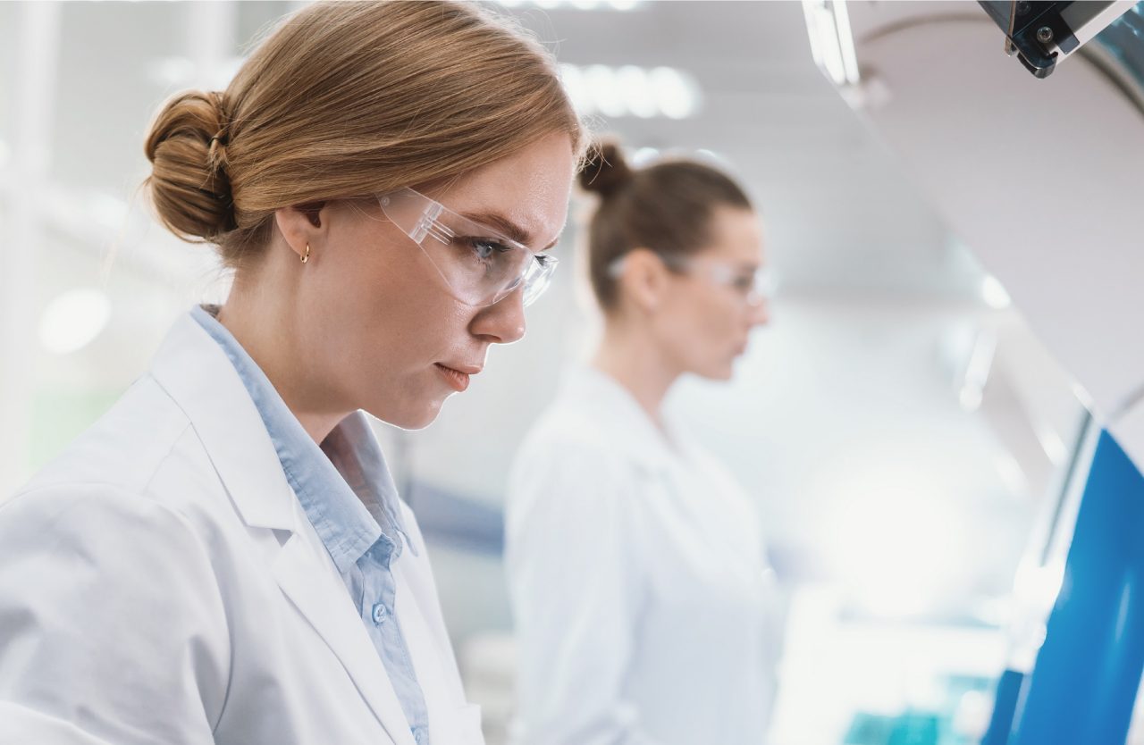 Two people stand together, working in lab 
